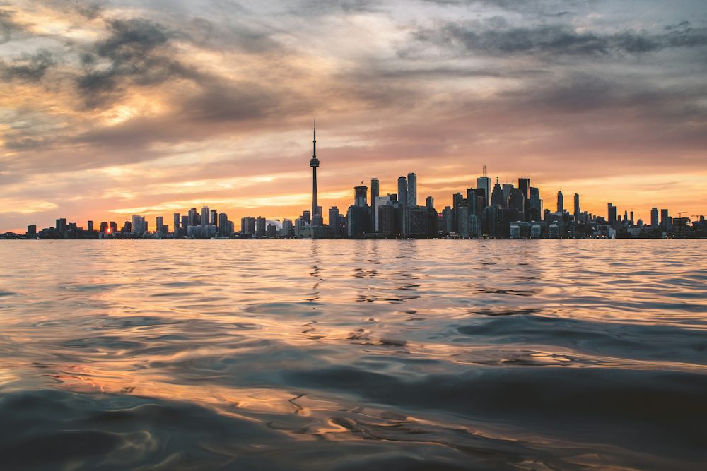 Toronto skyline across Lake Ontario at sunset